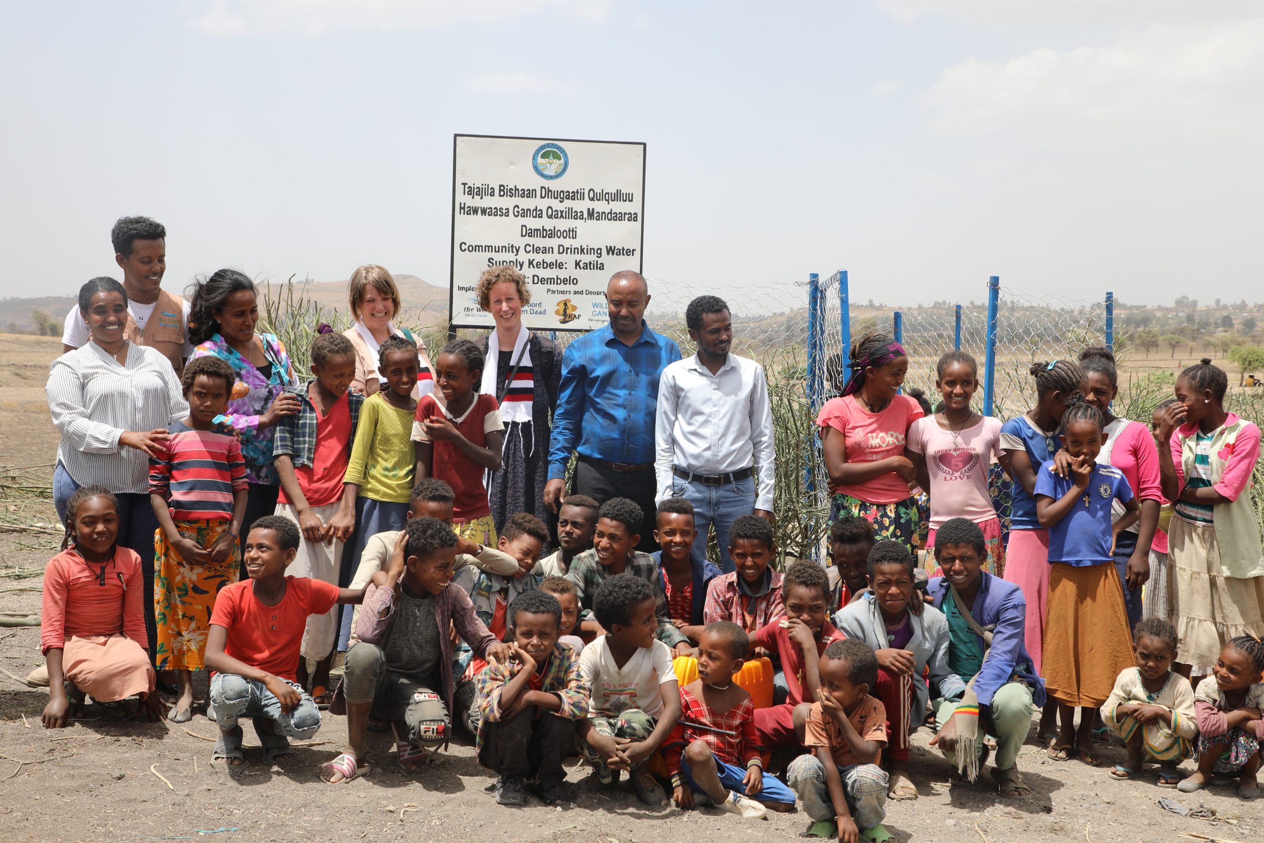 Een groepsfoto bij de waterput in Ethiopië met Linda en Esly.